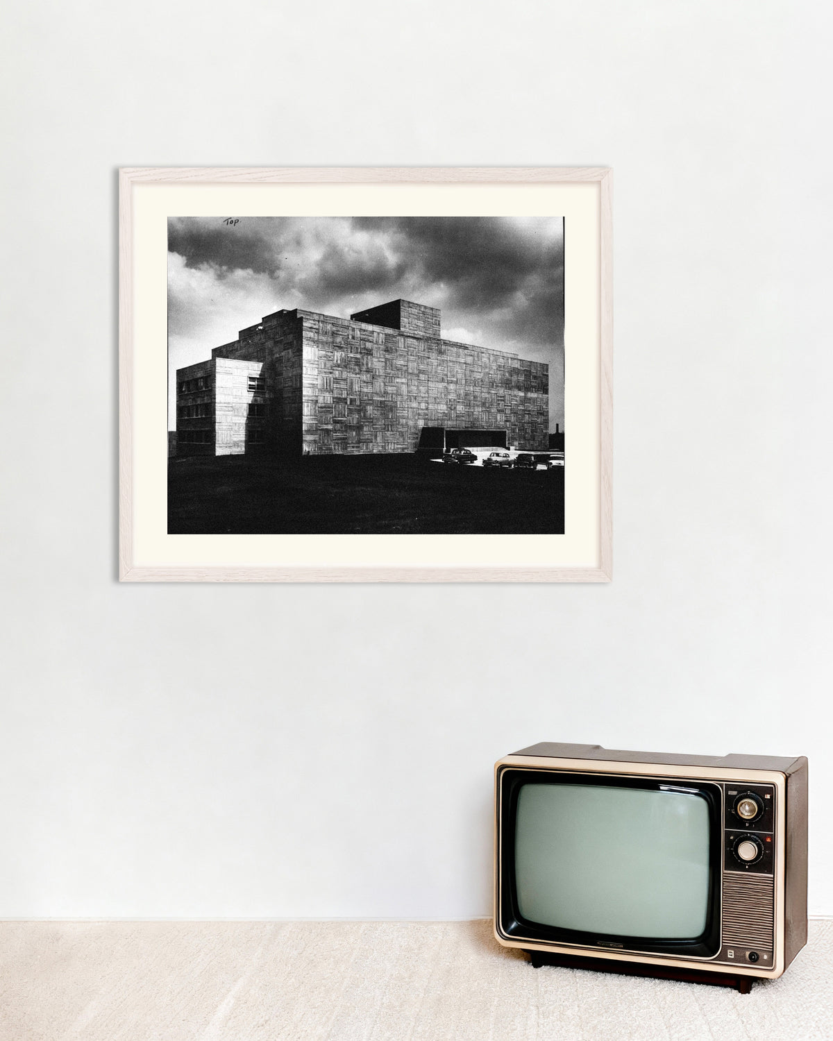 Poster ”Betongbyggnad under en storm”, med vit träram