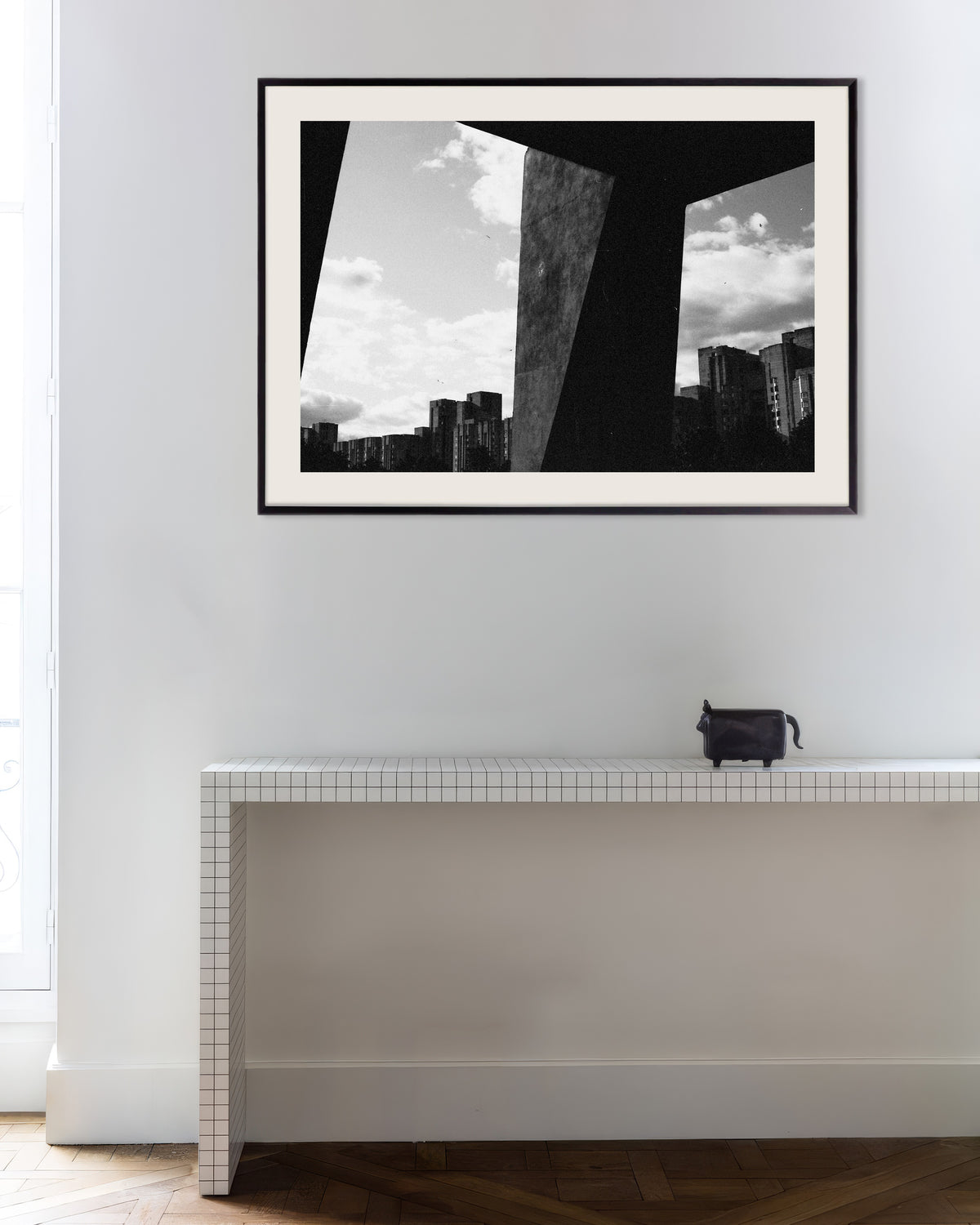 Poster ”Staden sedd mellan betongpelare”, med metallram
